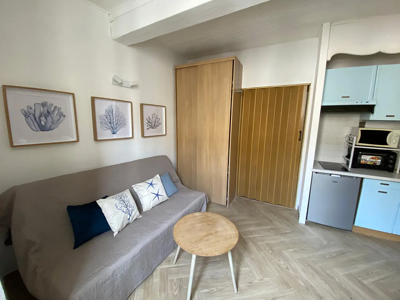 Salon avec canapé, armoire et cuisine